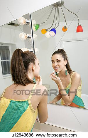 Looking in mirror applying makeup View Large Photo Image Stock Photograph - Looking in mirror applying makeup. Fotosearch