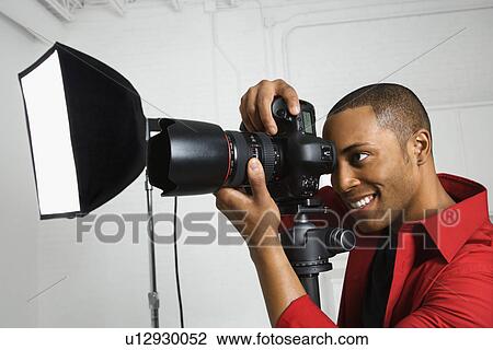 Stock Image - looking through camera on tripod. Fotosearch