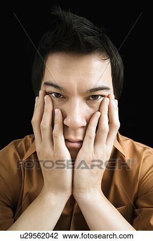 Portrait of young man with hands on face View Large Photo Image Stock Image - Portrait of young man with hands on face. Fotosearch