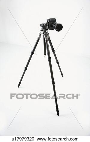 Stock Image - Studio shot of camera and tripod. Fotosearch