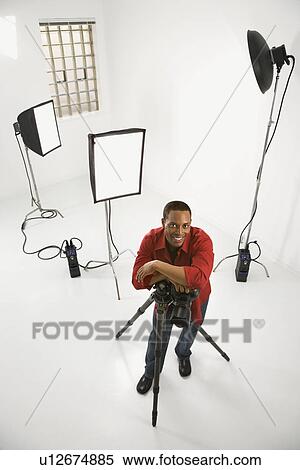 Stock Photography - Young African American male adult photographer posing in studio.. Fotosearch