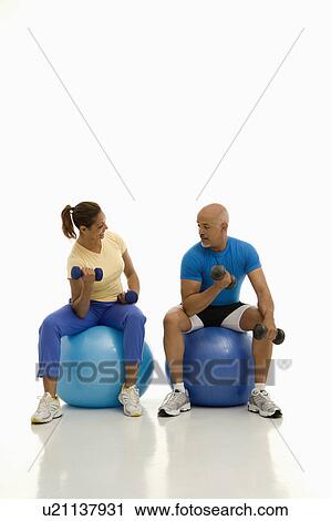 Balancing on exercise balls while working out with dumbbells View Large Photo Image Stock Image - Balancing on exercise balls while working out with dumbbells. Fotosearch
