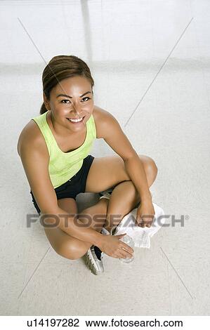 High angle view of mid adult woman sitting on floor with water bottle and smiling up at viewer. View Large Photo Image Stock Image - High angle view of mid adult woman sitting on floor with water bottle and smiling up at viewer.. Fotosearch