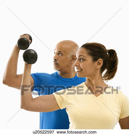 Man and woman exercising with dumbbells doing bicep curls View Large Photo Image Stock Photo - Man and woman exercising with dumbbells doing bicep curls. Fotosearch