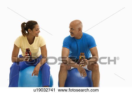 Man and woman sitting on blue exercise balls View Large Photo Image Stock Image - Man and woman sitting on blue exercise balls. Fotosearch