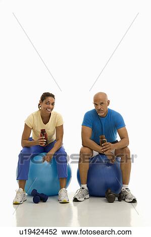 Man and woman sitting on blue exercise balls View Large Photo Image Stock Image - Man and woman sitting on blue exercise balls. Fotosearch