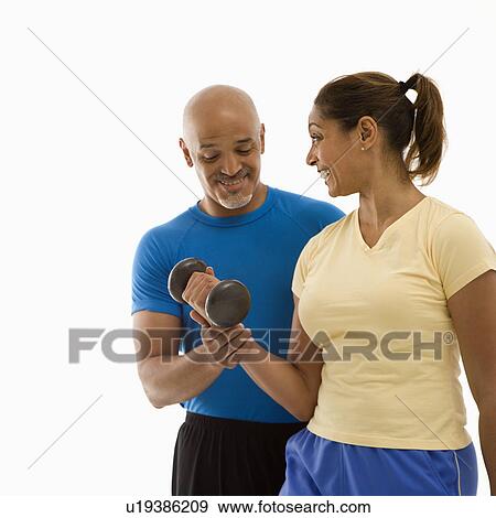Stock Photo - man assisting woman with dumbbells. Fotosearch