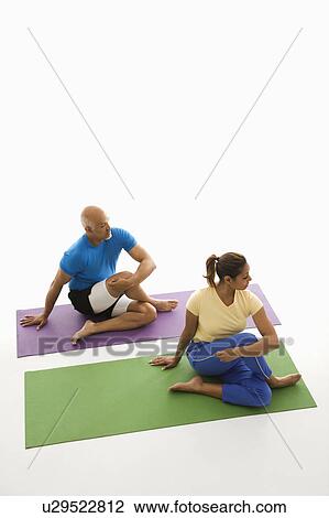 Mid adult man and woman sitting and stretching on exercise mats. View Large Photo Image Stock Image - Mid adult man and woman sitting and stretching on exercise mats.. Fotosearch