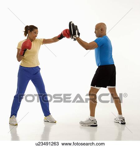 Mid adult woman standing and punching focus mitts worn by mid adult man. View Large Photo Image Stock Image - Mid adult woman standing and punching focus mitts worn by mid adult man.. Fotosearch