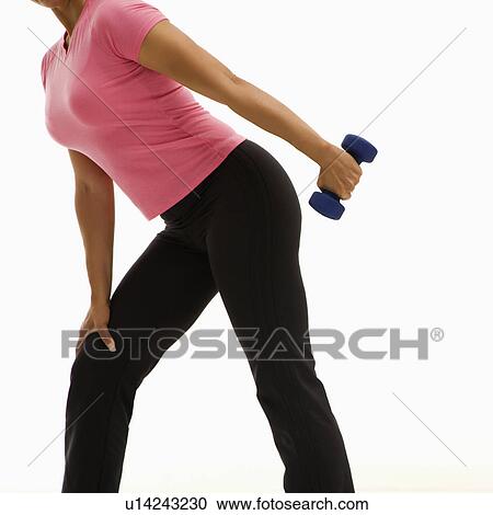 Side view of mid adult multiethnic woman wearing pink shirt exercising with dumbbell. View Large Photo Image Stock Image - Side view of mid adult multiethnic woman wearing pink shirt exercising with dumbbell.. Fotosearch