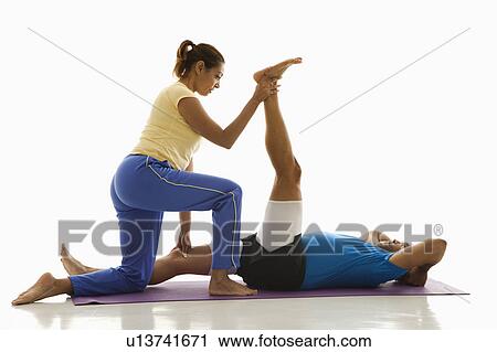 Side view of mid adult woman assisting mid adult man with stretching on exercise mat. View Large Photo Image Stock Image - Side view of mid adult woman assisting mid adult man with stretching on exercise mat.. Fotosearch