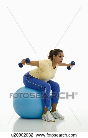 Woman balancing on blue exercise ball View Large Photo Image Stock Image - Woman balancing on blue exercise ball . Fotosearch