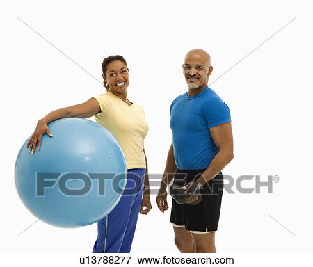 Woman holding blue exercise ball standing with man View Large Photo Image Stock Photo - Woman holding blue exercise ball standing with man . Fotosearch