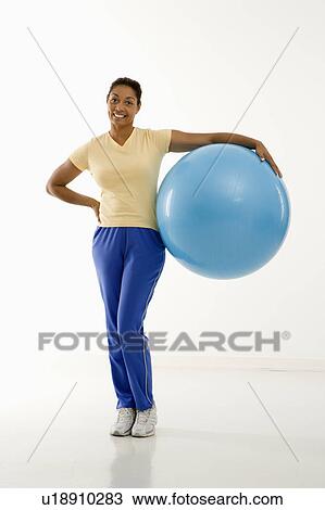 Woman standing with exercise ball View Large Photo Image Stock Image - Woman standing with exercise ball . Fotosearch
