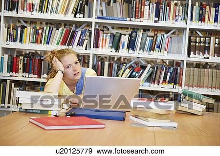 Bored young woman in library View Large Photo Image Stock Photo - Bored young woman in library. Fotosearch