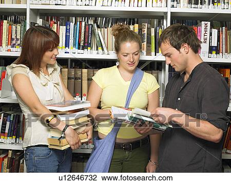 Stock Image - Group of young people in a library. Fotosearch