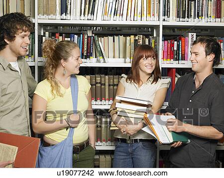 Stock Image - Group of young people in a library. Fotosearch