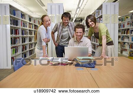 Young students in a library View Large Photo Image Stock Image - Young students in a library. Fotosearch