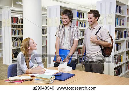 Young students in a library View Large Photo Image Stock Image - Young students in a library. Fotosearch