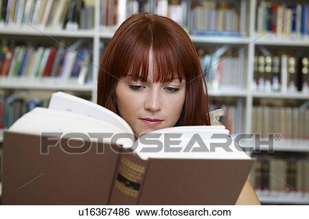 Young woman reading in library View Large Photo Image Stock Photograph - Young woman reading in library. Fotosearch