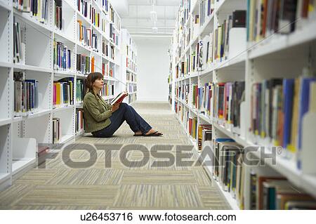 Young woman sitting on library floor View Large Photo Image Stock Photograph - Young woman sitting on library floor. Fotosearch