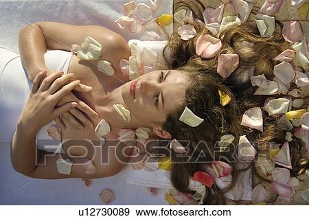 Above view of woman wrapped in sheet laying down with hair spread out on rose petals View Large Photo Image Stock Photo - Above view of woman wrapped in sheet laying down with hair spread out on rose petals. Fotosearch