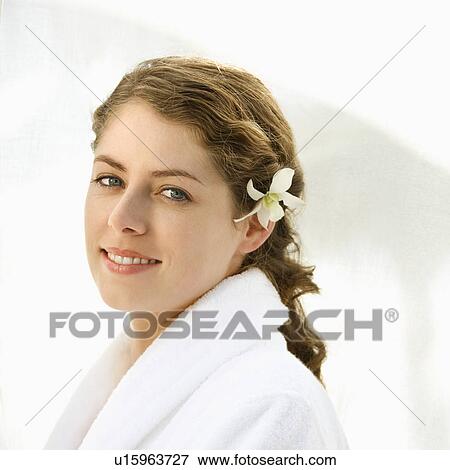 Attractive Caucasian mid-adult woman wearing robe with orchid flower in hair smiling at viewer. View Large Photo Image Stock Photo - Attractive Caucasian mid-adult woman wearing robe with orchid flower in hair smiling at viewer.. Fotosearch