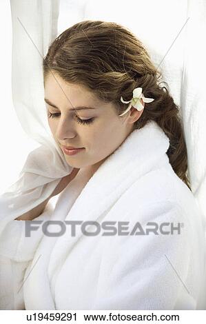 Pretty Caucasian mid-adult woman wearing white terry robe with white orchid flower in hair. View Large Photo Image Stock Image - Pretty Caucasian mid-adult woman wearing white terry robe with white orchid flower in hair.. Fotosearch