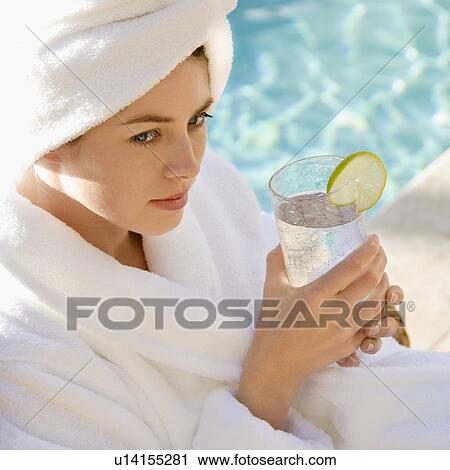 Woman wearing robe and towel on head drinking from glass next to pool View Large Photo Image Stock Image - Woman wearing robe and towel on head drinking from glass next to pool. Fotosearch