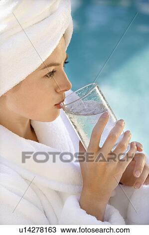 Woman wearing white terry robe drinking water next to pool View Large Photo Image Stock Image - Woman wearing white terry robe drinking water next to pool. Fotosearch
