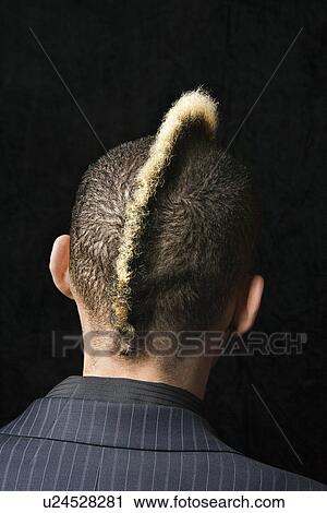 Stock Image - Back view portrait of Caucasian man in suit with mohawk against black background.. Fotosearch