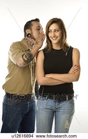 Caucasian mid-adult man whispering into ear of teen female. View Large Photo Image Picture - Caucasian mid-adult man whispering into ear of teen female.. Fotosearch