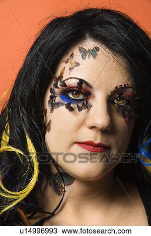 Stock Image - Head shot portrait of Caucasian woman with unique makeup and hair.. Fotosearch