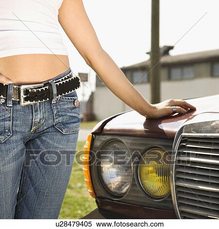 Midsection of young Caucasian woman standing beside automobile. View Large Photo Image Stock Photography - Midsection of young Caucasian woman standing beside automobile.. Fotosearch