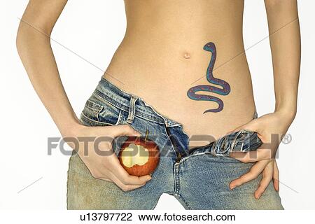 Portrait of attractive Caucasian young woman holding apple by snake tattoo on stomach. View Large Photo Image Stock Image - Portrait of attractive Caucasian young woman holding apple by snake tattoo on stomach.. Fotosearch