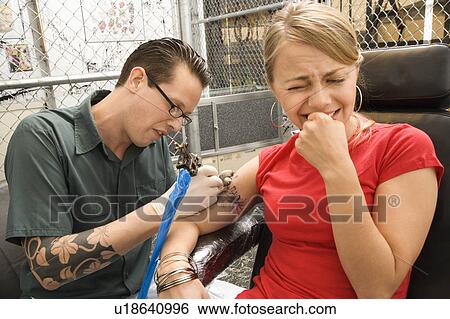 Tattoo artist tattooing woman View Large Photo Image Stock Photograph - Tattoo artist tattooing woman. Fotosearch