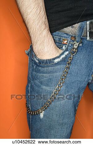 Stock Image - Young adult Caucasian male with hands in jean pocket and wallet chain.. Fotosearch