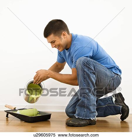 Attractive man smiling and pouring paint into roller pan in home. View Large Photo Image Stock Photography - Attractive man smiling and pouring paint into roller pan in home.. Fotosearch