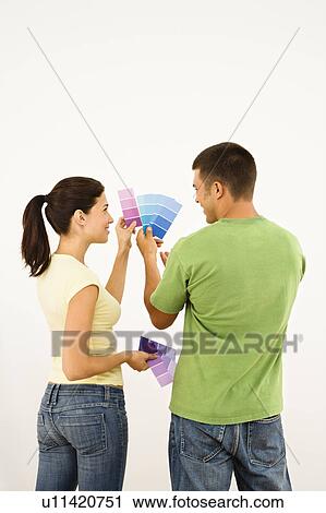 Attractive young adult couple holding color paint samples up to white wall. View Large Photo Image Stock Image - Attractive young adult couple holding color paint samples up to white wall.. Fotosearch