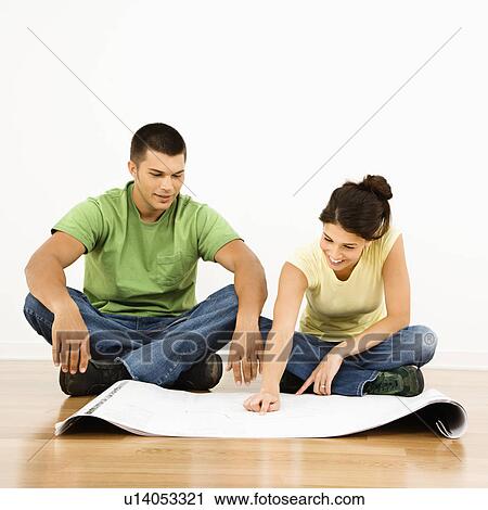 Attractive young adult couple looking at house plans. View Large Photo Image Stock Image - Attractive young adult couple looking at house plans.. Fotosearch