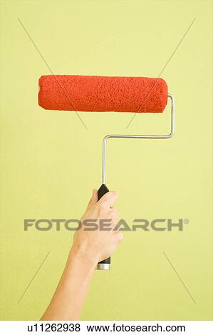 Caucasian female hand holding paint roller dipped in red against green wall. View Large Photo Image Stock Photo - Caucasian female hand holding paint roller dipped in red against green wall.. Fotosearch