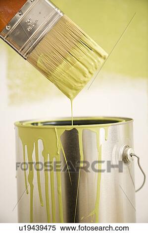 Stock Photography - Close up of paintbrush dripping over paint can.. Fotosearch