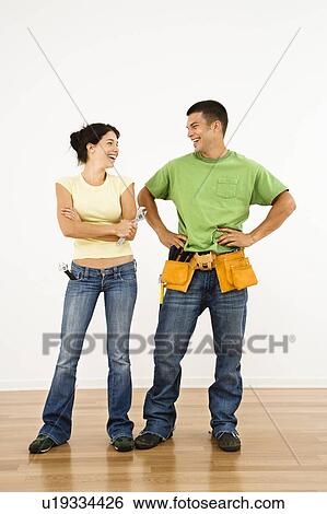 Stock Photograph - Couple with tools standing and smiling in home. Fotosearch