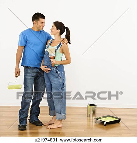 Pregnant Woman And Husband Preparing To Paint Interior Home