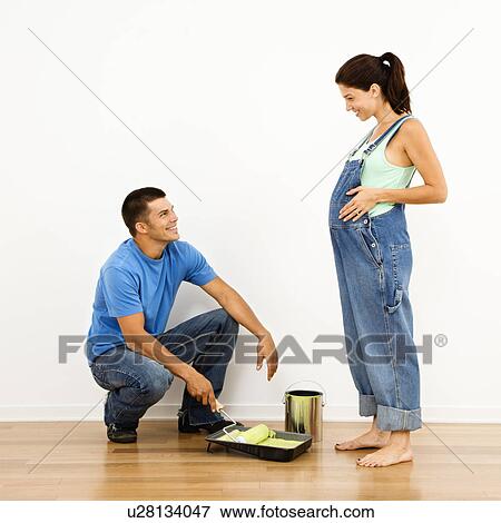 Pregnant Woman And Husband Preparing To Paint Interior Home