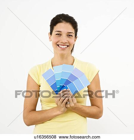 Stock Photo - Woman smiling holding out paint sample. Fotosearch