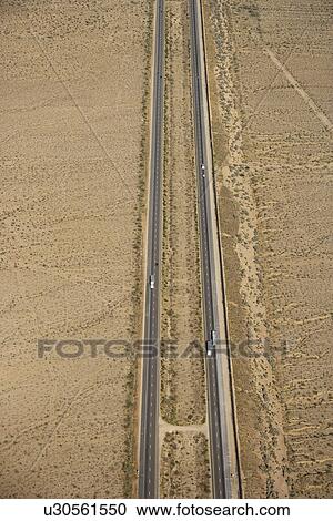 Stock Image - Aerial view of interstate through desert landscape.. Fotosearch
