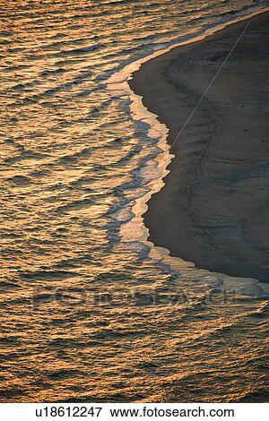 Stock Photo - Aerial view of sun over Atlantic ocean and shoreline of Bald Head Island, North Carolina. Fotosearch