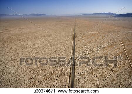 Aerial view of two lane highway in desert with mountains in background View Large Photo Image Stock Image - Aerial view of two lane highway in desert with mountains in background. Fotosearch