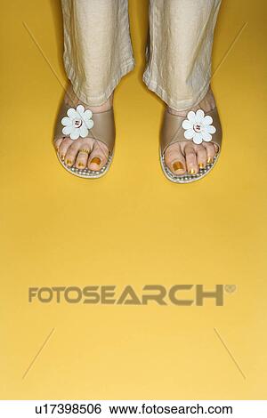 Stock Photograph - Female feet in open toed flower sandals. Fotosearch
